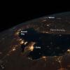 繁华的波斯湾在晚上 - 宇航员孤立在空间站